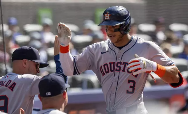 Houston Astros shortstop Jeremy Peña (3) is congratulated by manager Joe Espada, left, after hitting a solo home run against the Toronto Blue Jays in fifth-inning baseball game action in Toronto, Monday, July 1, 2024. (Frank Gunn/The Canadian Press via AP)