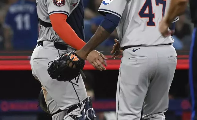 Houston Astros' Yainer Diaz, left, and relief pitcher Rafael Montero celebrate their team's victory over the Toronto Blue Jays after a baseball game in Toronto on Wednesday, July 3, 2024. (Jon Blacker/The Canadian Press via AP)