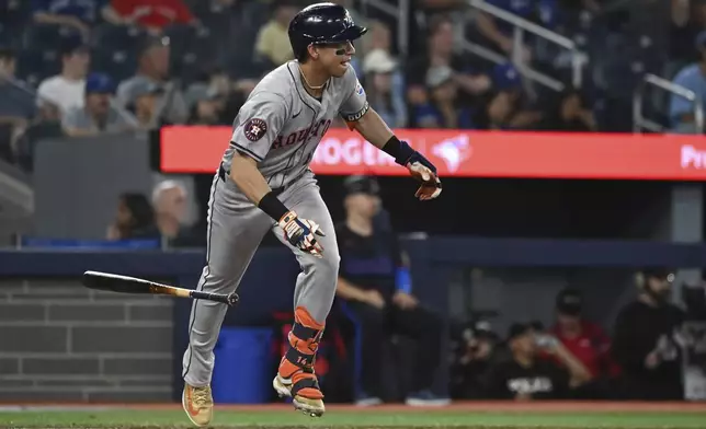 Houston Astros' Mauricio Dubon (14) hits a single against the Toronto Blue Jays during the ninth inning of a baseball game in Toronto on Wednesday, July 3, 2024. (Jon Blacker/The Canadian Press via AP)