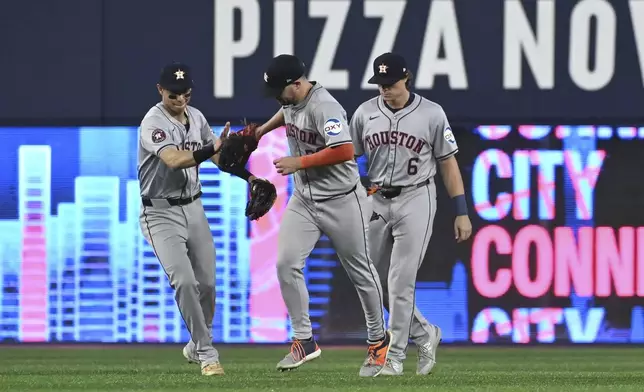 Houston Astros' Mauricio Dubon, from left, Chas McCormick (20) and Jake Meyers (6) celebrate their team's victory over the Toronto Blue Jays in a baseball game in Toronto on Wednesday, July 3, 2024. (Jon Blacker/The Canadian Press via AP)