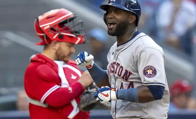 Houston Astros designated hitter Yordan Alvarez, right, celebrates in front of Toronto Blue Jays catcher Alejandro Kirk, left, as he crosses the plate after hitting a two-run home run in ninth-inning baseball game action in Toronto, Monday, July 1, 2024. (Frank Gunn/The Canadian Press via AP)