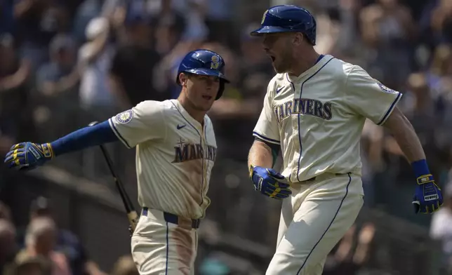 Seattle Mariners' Luke Raley, right, celebrates with Dylan Moore after hitting a three-run home run during the sixth inning of a baseball game against the Houston Astros, Sunday, July 21, 2024, in Seattle. (AP Photo/Stephen Brashear)