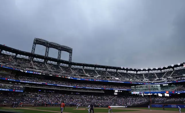 New York Mets' Adrian Houser pitches as a storm begins during the ninth inning of a baseball game against the Houston Astros, Sunday, June 30, 2024, in New York. (AP Photo/Pamela Smith)