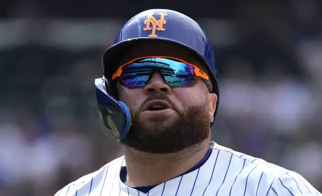 Citi Field is reflected in the sunglasses of New York Mets' DJ Stewart who runs to the dugout after grounding out during the eighth inning of a baseball game against the Houston Astros, Sunday, June 30, 2024, in New York. (AP Photo/Pamela Smith)