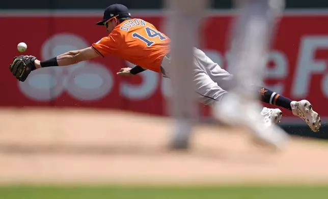 Houston Astros second baseman Mauricio Dubón (14) dives for a single hit by Minnesota Twins' Willi Castro during the first inning of a baseball game Saturday, July 6, 2024, in Minneapolis. (AP Photo/Abbie Parr)