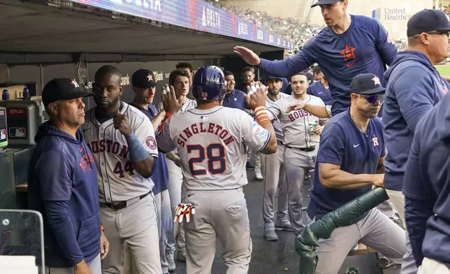 Houston Astros' Jonathan Singleton (28) celebrates in the dugout after scoring on a single hit by Cesar Salazar off Minnesota Twins starting pitcher Pablo Lopez during the second inning of a baseball game Friday, July 5, 2024, in Minneapolis. (AP Photo/Craig Lassig)