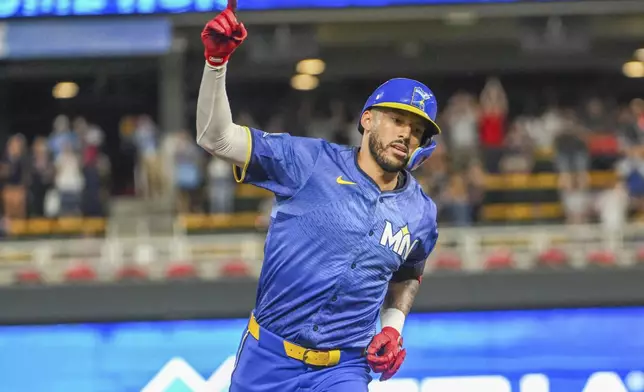 Minnesota Twins' Carlos Correa celebrates as he rounds the bases after hitting a grand slam during the ninth inning of a baseball game against the Houston Astros, Friday, July 5, 2024, in Minneapolis. Willi Castro, Christian Vazquez and Brooks Lee also scored on the hit. (AP Photo/Craig Lassig)