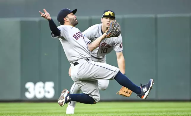 Houston Astros second baseman Jose Altuve, left, catches a fly ball hit by Minnesota Twins' Carlos Correa as right fielder Joey Loperfido, right, watches during the second inning of a baseball game Friday, July 5, 2024, in Minneapolis. (AP Photo/Craig Lassig)