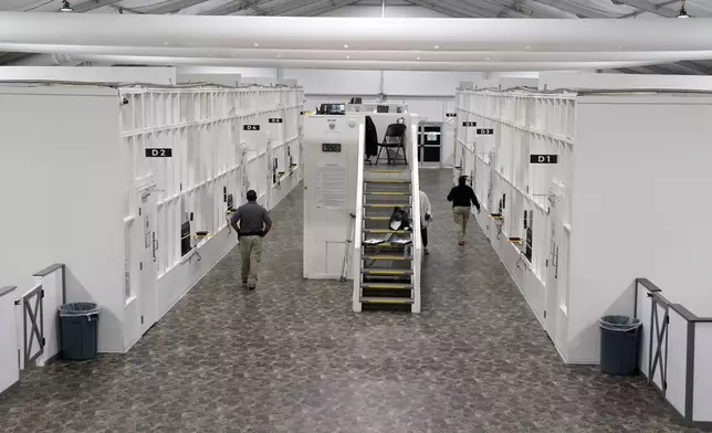 FILE - Agents walk among rooms at a Border Patrol holding facility on Dec. 15, 2023, in Tucson, Ariz. (AP Photo/Gregory Bull, File)