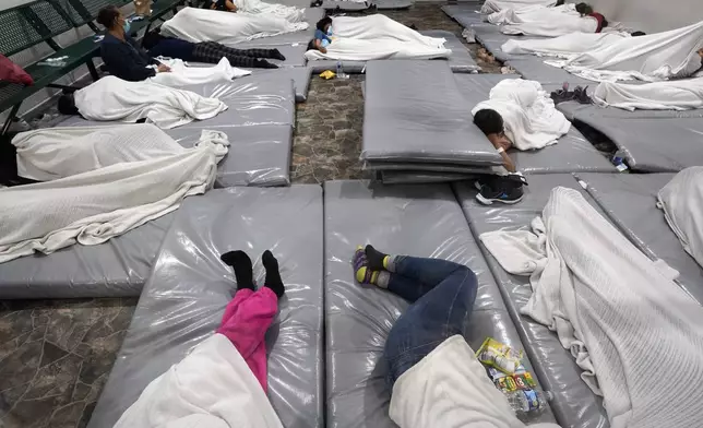 FILE - Women wait in a Border Patrol holding facility Friday, Dec. 15, 2023, in Tucson, Ariz. (AP Photo/Gregory Bull, File)