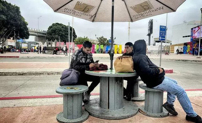 Christian Gutierrez, 26, center sits with other Mexicans who were deported from the United States to Tijuana, Mexico, on Tuesday, June 11, 2024. (AP Photo/Elliot Spagat)