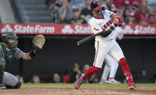 Los Angeles Angels' Zach Neto, right, swings at a pitch during the fourth inning of a baseball game against the Oakland Athletics in Anaheim, Calif., Friday, July 26, 2024. (AP Photo/Eric Thayer)