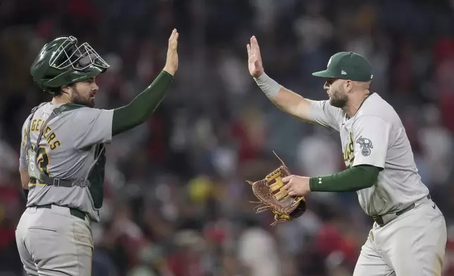 Oakland Athletics catcher Shea Langeliers (23) and first baseman Seth Brown high-five after a baseball game against the Los Angeles Angels in Anaheim, Calif., Friday, July 26, 2024. (AP Photo/Eric Thayer)