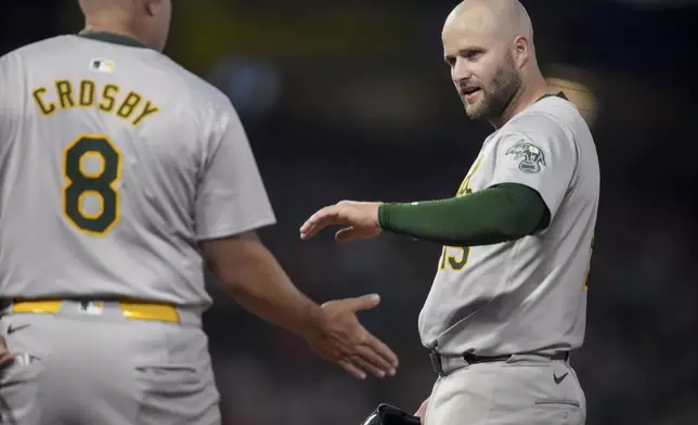 Oakland Athletics first base coach Bobby Crosby (8) celebrates with Seth Brown, who drove in a run, during the sixth inning of a baseball game against the Los Angeles Angels in Anaheim, Calif., Friday, July 26, 2024. (AP Photo/Eric Thayer)