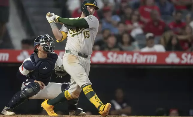 Oakland Athletics first baseman Seth Brown (15) hits a single during the sixth inning of a baseball game against the Los Angeles Angels in Anaheim, Calif., Friday, July 26, 2024. (AP Photo/Eric Thayer)