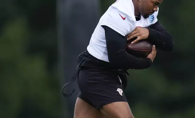 Atlanta Falcons running back Bijan Robinson (7) runs a drill during an NFL training camp football practice Thursday, July 25, 2024, in Flowery Branch, Ga. (AP Photo/John Bazemore)