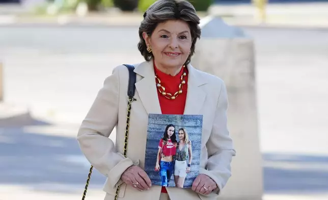 Attorney Gloria Allred arrives at the courthouse for actor Alec Baldwin's involuntary manslaughter trial while holding a photograph of "Rust" film cinematographer Halyna Hutchins Thursday, July 11, 2024, in Santa Fe, NM. Allred represents the Ukraine-based parents of Hutchins and a sister of the deceased cinematographer in a civil lawsuit against Baldwin and other "Rust" producers and the film's gun-safety crew. (AP Photo/Ross D. Franklin)