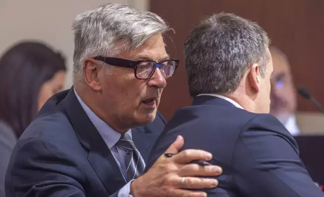 Actor Alec Baldwin, left, speaks with his attorney, Alex Spiro, in District Court in Santa Fe, NM, during a preliminary hearing for the "Rust" trial on Monday, July 8, 2024. Baldwin faces a single charge of involuntary manslaughter in the death of a cinematographer on the set of the film, "Rust." (Luis Sánchez Saturno/Santa Fe New Mexican via AP)