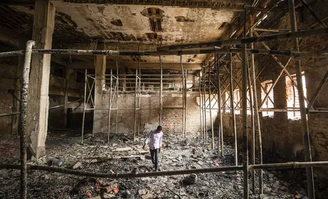 A man walks inside a burnt studio of the state-owned Bangladesh Television (BTV) in Dhaka, Bangladesh, Wednesday, July 24, 2024. (AP Photo/Rajib Dhar)