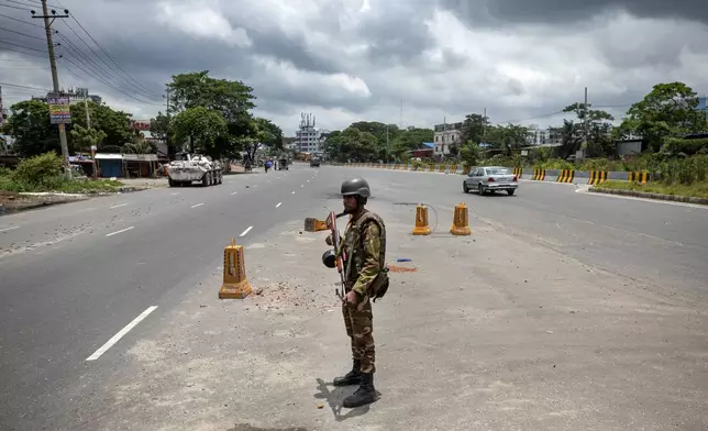 A military person stands guard on a highway on the fourth day of curfew imposed by the government amidst the countrywide deadly clashes, in Dhaka, Bangladesh, Tuesday, July 23, 2024. Internet and mobile data services are still down despite apparent calm in Bangladesh following a verdict that scaled back a controversial quota system for government jobs after weeks of relentless protests that turned deadly. (AP Photo/Rajib Dhar)