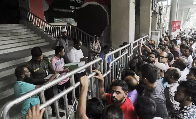 People gather in front of Titas Gas office to pay for cooking gas in cash as online service was not available due to Internet outage on the fourth day of curfew imposed by the government amidst the countrywide deadly clashes in Dhaka, Bangladesh, Tuesday, July 23, 2024. Internet and mobile data services are still down despite apparent calm in Bangladesh following a verdict that scaled back a controversial quota system for government jobs after weeks of relentless protests that turned deadly. (AP Photo/Anik Rahman)