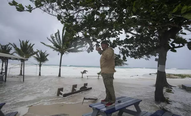 Rick Burn takes photos of damages caused by Hurricane Beryl in Hastings, Barbados, Monday, July 1, 2024. (AP Photo/Ricardo Mazalan)