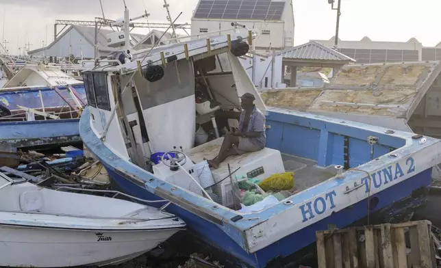 Fisherman Hamilton Cosmos looks at vessels damaged by Hurricane Beryl at the Bridgetown Fisheries in Barbados, Monday, July 1, 2024. (AP Photo/Ricardo Mazalan)