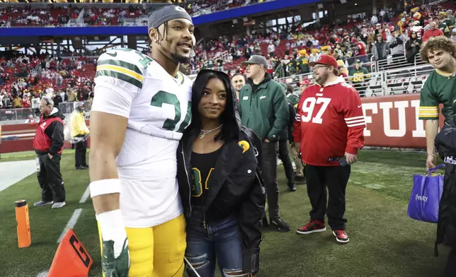 FILE - Then-Green Bay Packers' Jonathan Owens (34) and Simone Biles pose for a photo before an NFL football NFC divisional playoff game against the San Francisco 49ers, Jan. 20, 2024, in Santa Clara, Calif. Chicago Bears safety Owens has arranged to take leave from training camp and is heading to Paris, Monday, July 29, 2024, to watch his wife Biles compete for the U.S. gymnastics team. (AP Photo/Jed Jacobsohn, File)