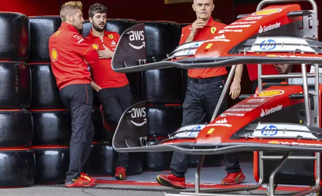 Ferrari crew stand in their team garage ahead of the Formula One Grand Prix at the Spa-Francorchamps racetrack in Spa, Belgium, Thursday, July 25, 2024. The Belgian Formula One Grand Prix will take place on Sunday. (AP Photo/Geert Vanden Wijngaert)