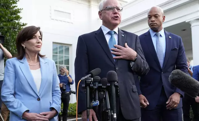 Minnesota Gov. Tim Walz, center, standing with New York Gov. Kathy Hochul, left, and Maryland Gov. Wes Moore, right, talks with reporters following their meeting with President Joe Biden at the White House in Washington, Wednesday, July 3, 2024. (AP Photo/Susan Walsh)