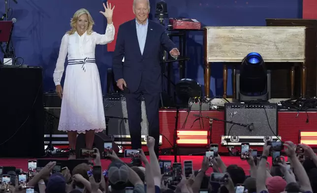 President Joe Biden and first lady Jill Biden arrive on stage to speak to active-duty military service members and their families during a Fourth of July celebration and barbecue on the South Lawn of the White House in Washington, Thursday, July 4, 2024. (AP Photo/Susan Walsh)