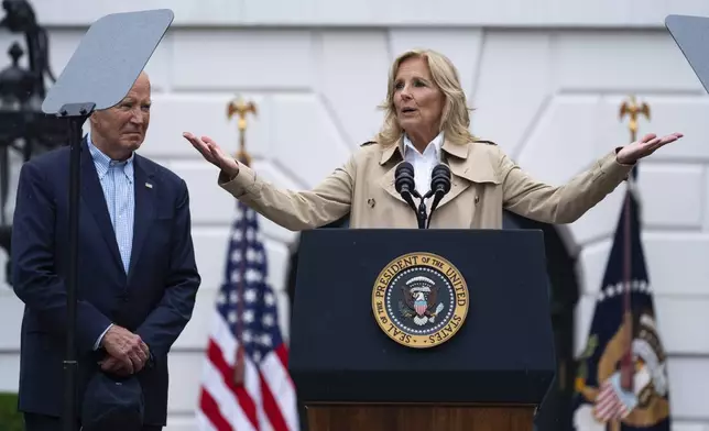 President Joe Biden listens as first lady Jill Biden speaks during a barbecue with active-duty military service members and their families on the South Lawn of the White House, Thursday, July 4, 2024, in Washington. (AP Photo/Evan Vucci)