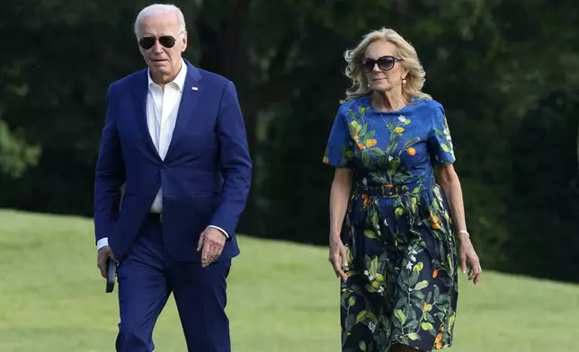 President Joe Biden, left, and first lady Jill Biden walk on the South Lawn of the White House in Washington, Sunday, July 7, 2024, after returning from events in Pennsylvania. (AP Photo/Susan Walsh)