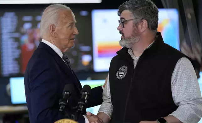 President Joe Biden greets Clint Osborn, acting director of the D.C. Homeland Security and Emergency Management Agency, after he spoke during a visit to the D.C. Emergency Operations Center, Tuesday, July 2, 2024, in Washington. (AP Photo/Evan Vucci)
