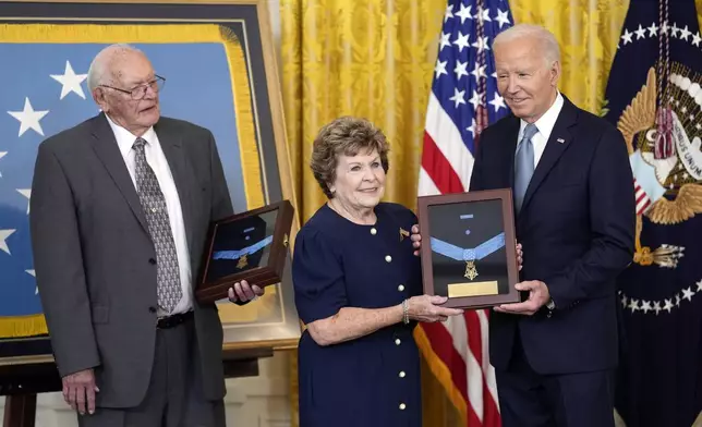 President Joe Biden presents the Medal of Honor to Theresa Chandler, the great great granddaughter of Pvt. George D. Wilson in the East Room at the White House in Washington, Wednesday, July 3, 2024. The medals posthumously honor two U.S. Army privates who were part of a daring Union Army contingent that stole a Confederate train during the Civil War. U.S. Army Pvts. Philip G. Shadrach and George D. Wilson were captured by Confederates and executed by hanging. At left is Gerald Taylor, the great great nephew of Pvt. Philip G. Shadrach. (AP Photo/Susan Walsh)
