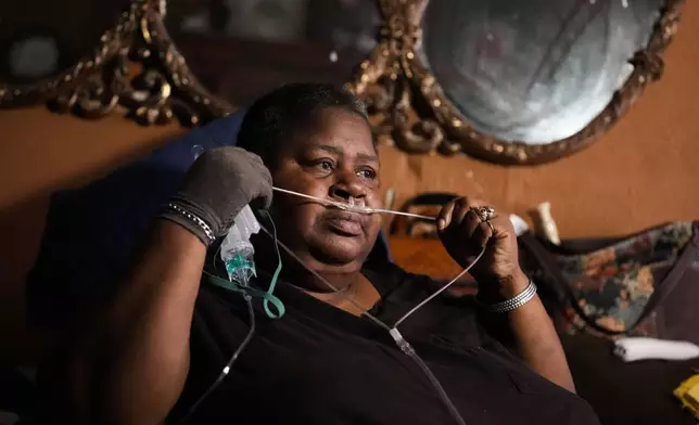 Shelia Mae Dobbins holds part of her oxygen tube inside her home in Gloster, Miss., Wednesday, May 29, 2024. Dobbins feels her life — and health — were better before Drax began compressing tons of wood chips nearby. (AP Photo/Gerald Herbert)