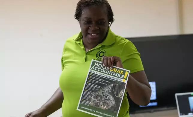 Krystal Martin, a Gloster native, shows pamphlets during a community meeting she organized regarding health complaints against the Drax facility in Gloster, Miss., Thursday, May 2, 2024. (AP Photo/Gerald Herbert)