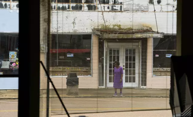 A resident crosses the street for a community meeting regarding health complaints against Drax in Gloster, Miss., Thursday, May 2, 2024. (AP Photo/Gerald Herbert)