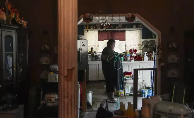 Shelia Mae Dobbins walks with her oxygen tube inside her home in Gloster, Miss., Wednesday, May 29, 2024. Dobbins feels her life — and health — were better before Drax began compressing tons of wood chips nearby, (AP Photo/Gerald Herbert)