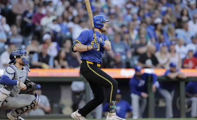 Seattle Mariners' Luke Raley, right, hits a two-RBI double against the Toronto Blue Jays during the third inning in a baseball game, Friday, July 5, 2024, in Seattle. (AP Photo/John Froschauer)