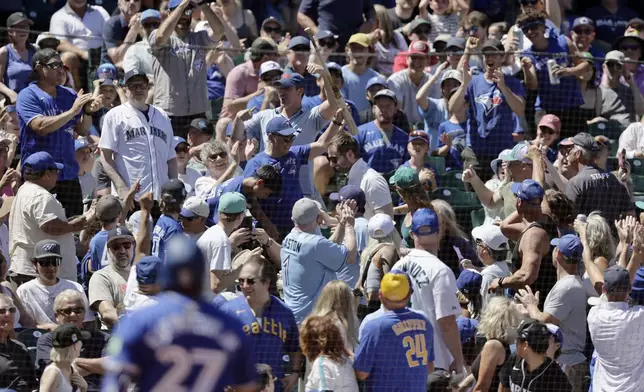 A fan holds up the bat Toronto Blue Jays' Vladimir Guerrero Jr. lost on a swing during the fifth inning in a baseball game against the Seattle Mariners, Saturday, July 6, 2024, in Seattle. (AP Photo/John Froschauer)