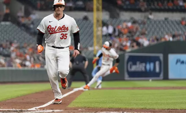 Baltimore Orioles' Adley Rutschman (35) advances toward home base to score followed by Gunnar Henderson on an RBI hit in by Ryan O'Hearn during the third inning of a baseball game against the Toronto Blue Jays, Tuesday, July 30, 2024, in Baltimore. (AP Photo/Stephanie Scarbrough)