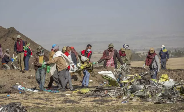 FILE - Rescuers work at the scene of an Ethiopian Airlines Boeing Max crash near Bishoftu, or Debre Zeit, south of Addis Ababa, Ethiopia, on March 11, 2019. Ike Riffel , a California father whose two sons died in the crash, fears that instead of putting Boeing on trial, the government will offer the company another shot at corporate probation through a legal document called a deferred prosecution agreement, or DPA. (AP Photo/Mulugeta Ayene, File)