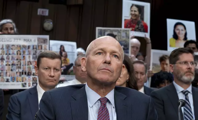 FILE - With protesters in the audience, Boeing CEO Dave Calhoun waits to testify before the Senate Homeland Security and Governmental Affairs Subcommittee on Investigations at the Capitol in Washington, Tuesday, June 18, 2024. On Sunday, July 7, 2024, the Justice Department said Boeing has agreed to plead guilty to a criminal fraud charge stemming from two deadly crashes of 737 Max jetliners.(AP Photo/J. Scott Applewhite, File)