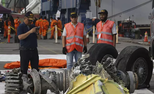 FILE - Officials inspect an engine recovered from the crashed Lion Air jet in Jakarta, Indonesia, Nov. 4, 2018. The brand new Boeing 737 MAX 8 jet plunged into the Java Sea just minutes after takeoff from Jakarta early on Oct. 29, killing all of its passengers on board. On Sunday, July 7, 2024, the Justice Department said Boeing has agreed to plead guilty to a criminal fraud charge stemming from two deadly crashes of 737 Max jetliners. (AP Photo/Achmad Ibrahim, File)