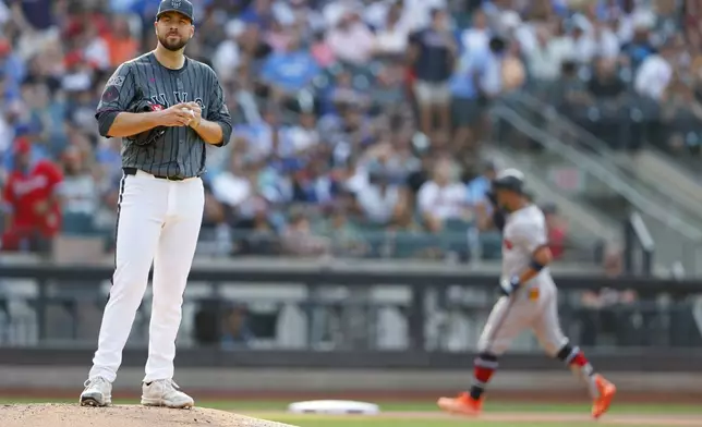 New York Mets pitcher Tylor Megill (38) rubs a new ball as Atlanta Braves' Eddie Rosario rounds the bases after hitting a home run in the seventh inning of a baseball game, Saturday, July 27, 2024, in New York. (AP Photo/Rich Schultz)