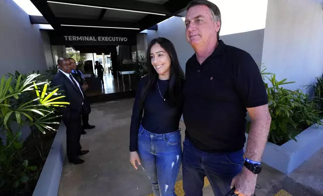 Former Brazilian President Jair Bolsonaro poses for a photo with a supporter during his arrival to the international airport in Brasilia, Brazil, Friday, July 5, 2024. Brazilian police have indicted Bolsonaro for money laundering and criminal association in connection with undeclared diamonds the far-right leader received from Saudi Arabia during his time in office, according to a source with knowledge of the accusations. (AP Photo/Eraldo Peres)