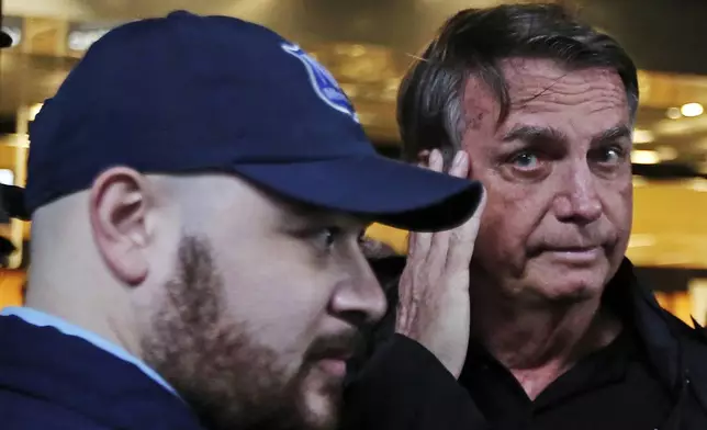 Brazilian former President Jair Bolsonaro arrives at the international airport in Florianopolis, Santa Catarina state, Brazil, Friday, July 5, 2024. Brazilian police have indicted Bolsonaro for money laundering and criminal association in connection with undeclared diamonds the far-right leader received from Saudi Arabia during his time in office, according to a source with knowledge of the accusations. (AP Photo/Heuler Andrey)