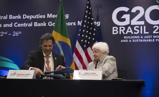 U.S. Treasury Secretary Janet L. Yellen, right, and Brazilian Economy Minister Fernando Haddad sign a Joint Statement on the Climate Partnership by Brazil's Ministry of Finance and the U.S. Department of the Treasury, during the G20 economic ministers' meeting, in Rio de Janeiro, Brazil, Friday, July 26, 2024. (AP Photo/Bruna Prado)