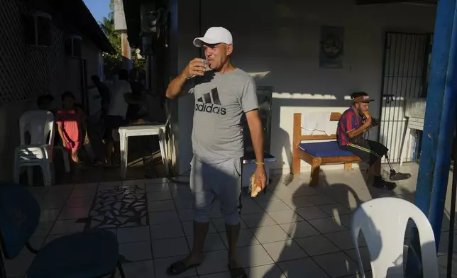 Cuban migrant Miguel Hidalgo drinks a glass of milk during breakfast at a shelter Rio Branco, Brazil, Saturday, June 22, 2024. Hidalgo who tried to cross to the U.S. years ago says, “I like Brazil. I have been here for a short time, but people are not prejudiced against me, people are lovely,” he said. (AP Photo/Martin Mejia)